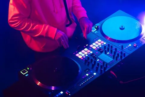 Hands of a DJ creating and regulating music on dj console mixer at club concert Stock Photos