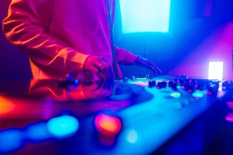 Hands of a DJ creating and regulating music on dj console mixer at club concert Stock-Fotos