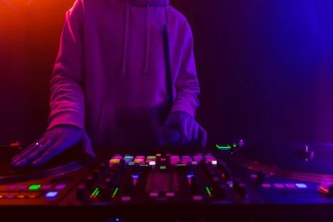 Hands of a DJ creating and regulating music on dj console mixer at club concert Stock Photos