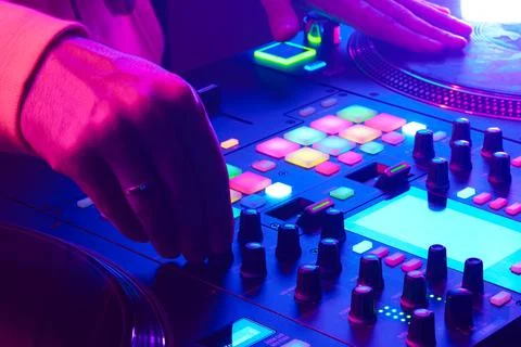Hands of a DJ creating and regulating music on dj console mixer at club concert Stock Photos