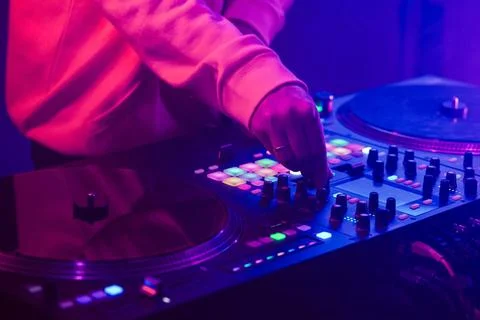 Hands of a DJ creating and regulating music on dj console mixer at club concert Stock Photos