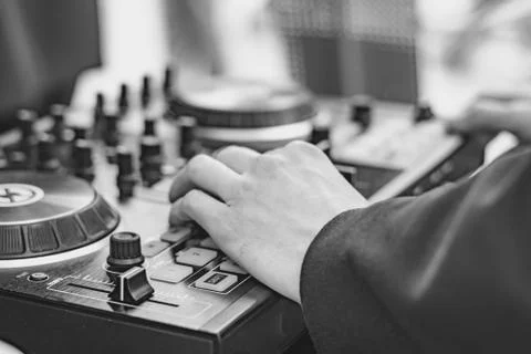 The hands of the DJ on the remote control Photos