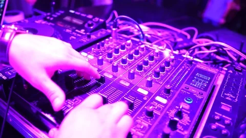 Hands of DJ tweak various track controls on dj's deck Stock Footage 86895132