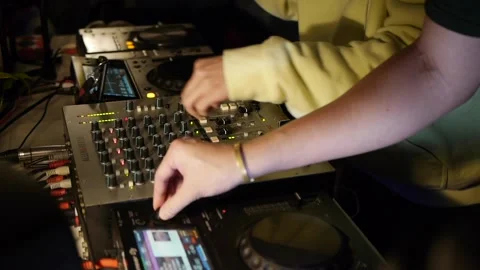 Hands of DJ tweaking mixer and selecting songs during live performance Stock Footage 171121772