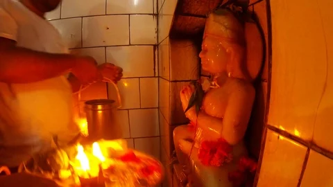 Hands do puja ritual prayer with candle to statue of godess devi Parvati ancient Vídeo Stock 98373870