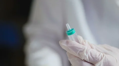 The hands of the doctor in gloves remove the healed cap from the needle of the Stock Footage 99482743