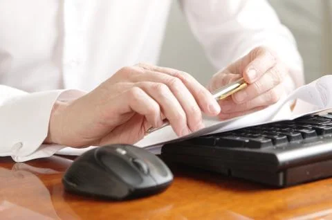 Hands with document on a computer keyboard Stock Photos