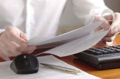 Hands with document on a computer keyboard Stock Photos