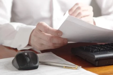 Hands with document on a computer keyboard Stock Photos
