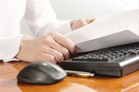 Hands with document on a computer keyboard Stock Photos