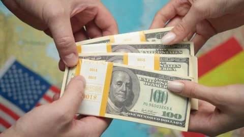 Hands dollars to Spanish partner among global map and US-Spanish flags for Stock Footage 331263870