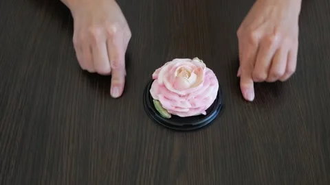 Hands draw a heart on the table around a marshmallow rose flower. Holiday g.. Vídeo Stock 332795386