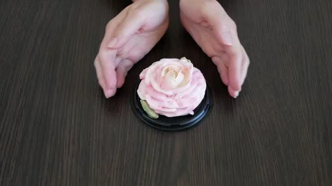 Hands draw a heart on the table around a marshmallow rose flower. Holiday g.. Stock Footage 332795390