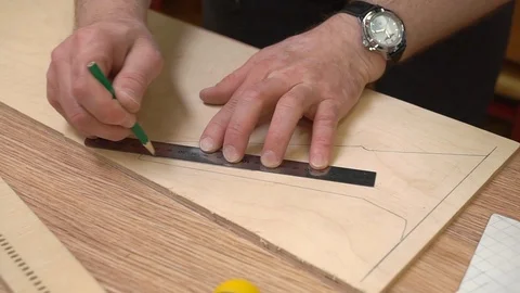 Hands draw lines on brown veneer with metal ruler and pencil Stock-Footage 126895546