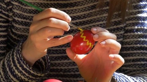 Hands draw patterns on the Easter egg Video stock 73456424