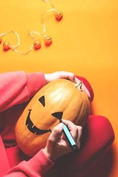 Hands drawing face on pumpkin. Foto stock
