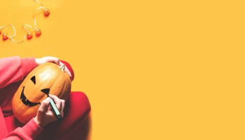Hands drawing face on pumpkin. Stock Photos