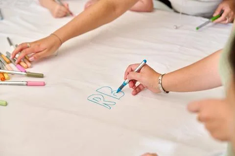 Hands drawing with markers on large white paper surface Stock Photos