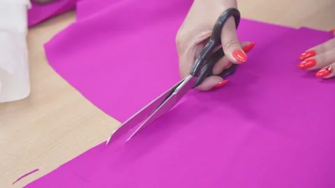 Hands of dressmaker with scissors in her hands are working on sewing dress. Stock Footage 250337777