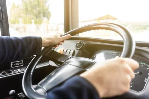 Hands of the driver in a modern bus according to the ride, detail of the bus 库存照片