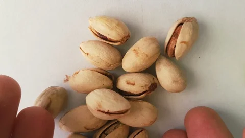 Hands that drop a group of pistachios Stock Footage 101035386