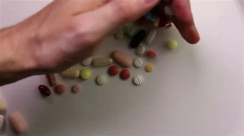 Hands dropping many pills Stock Footage 7130728