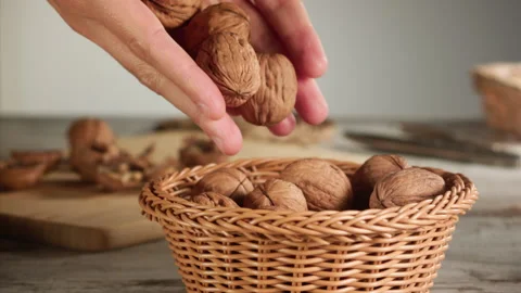 Hands dropping nuts into a basket in slow motion Stock Footage 152176338
