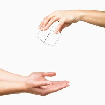 Hands dropping white cube on white background Stock Photos