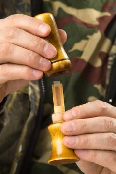 Hands of the duck hunter dismantled a single reed call Stock Photos