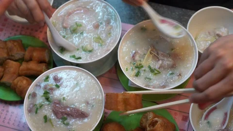Hands eating congee boil rice and fried dough Hong Kong Cantonese style break Vídeos de archivo 123530221