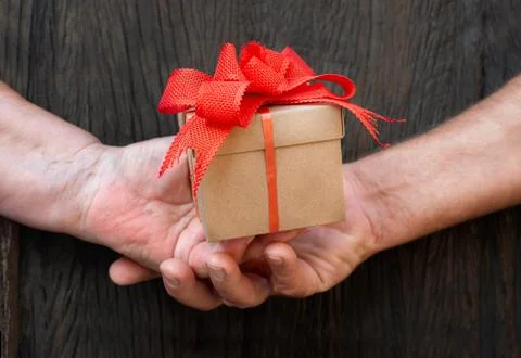 Hands of elderly hold the gift box Stock Photos