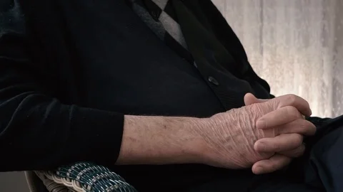 Hands elderly man grasps his hand on lap,  Stock Footage 104087216
