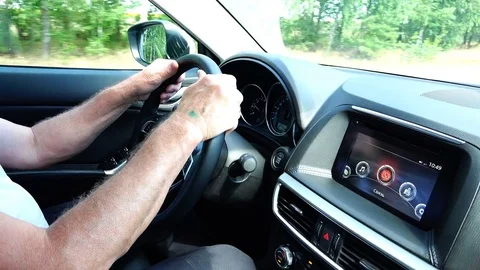 The hands of the elderly man hold the steering wheel of the car and drive the Stock Footage 85437582