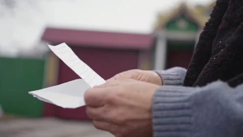 Hands of elderly man holding letter and envelope from friend Stock Footage 230692186