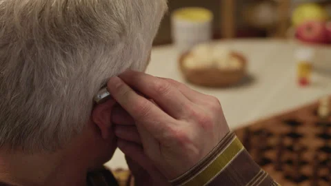 Hands of Elderly Man Putting On Hearing Aid Stock Footage 323927711