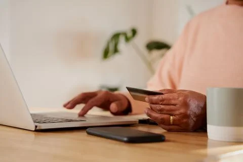 Hands of elderly multi-ethnic female making online payment on laptop, sitting at Stock Photos