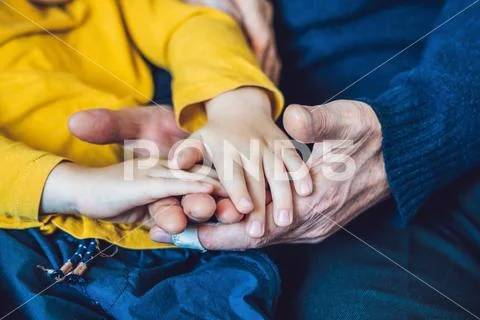 The hands of an elderly person and the hands of a child, the continuity of ge Stock Photos