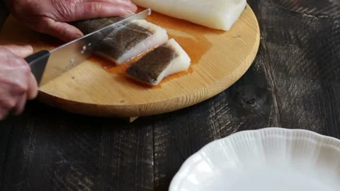 Hands of elderly woman cutting a cod fillet with knife on cutting board Stock-Footage 151161705