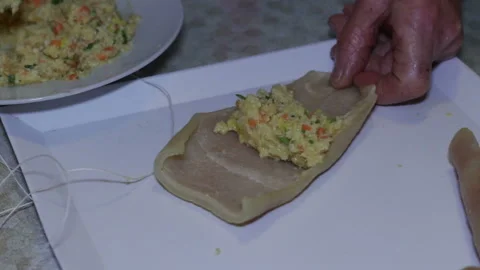 Hands of elderly woman preparing stuffed pork rind. Stock Footage 152879061