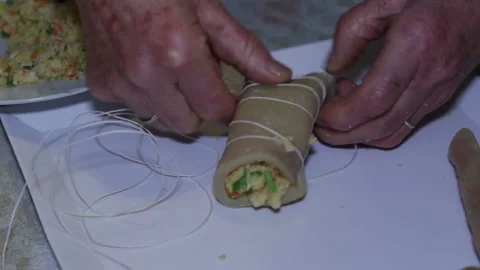 Hands of elderly woman preparing stuffed pork rind. Stock Footage 152879488