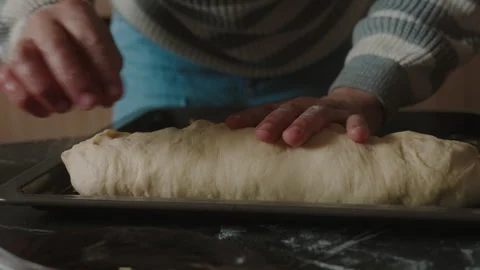 Hands of an elderly woman putting the dough on the tray to spread it with oil Stock Footage 240599341