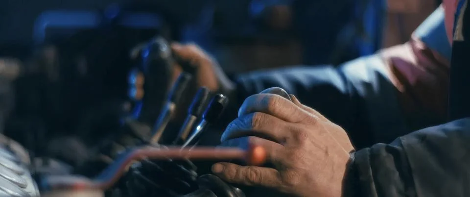 Hands of an elderly worker on control levers of a mining excavator. Stock Photos