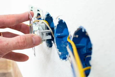 Hands of electrician installing electrical socket with new home Stock Photos