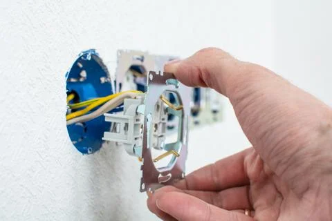 Hands of electrician installing electrical socket with new home Stock Photos