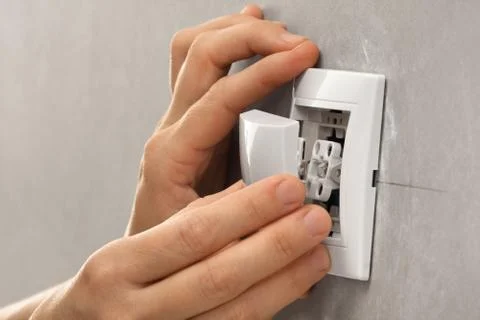 Hands  of electrician installing light switch Stock Photos