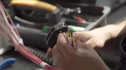 The hands of the electrician use a tool to crimp the lugs on the cable. Stock Footage 169414246