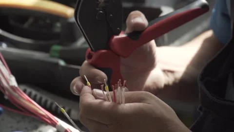 The hands of the electrician use a tool to crimp the lugs on the cable. Stock Footage 169414287