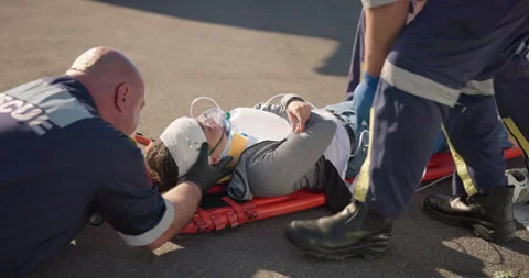 Hands, emergency oxygen and a paramedic group with a patient or victim on the 스톡 동영상 252655376