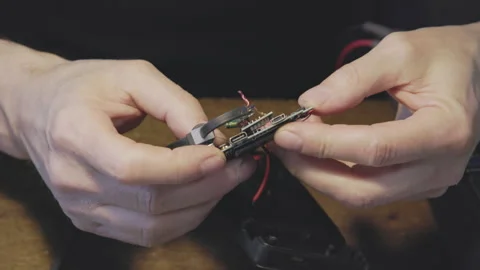 Hands Engaged in the Detailed Work of Circuit Board Repair and Maintenance Stock Footage 306060225