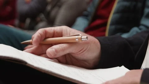Hands engaged in note-taking during a conference session focusing on important Stock Footage 318788097